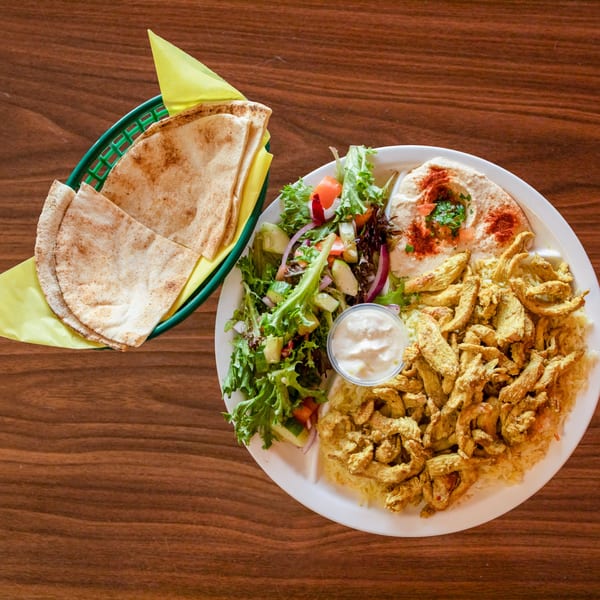 Zest Mediterranean Cuisine's chicken shawarma plate with rice, hummus, salad, and pita bread.